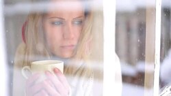 Woman having a tea or coffee on snowy day. Stock Footage
