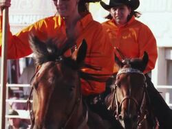Group of riders with flags and horses perform a routine at a rodeo - shot in slow motion. Stock Footage