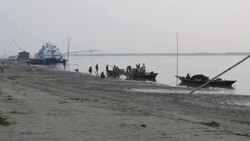 Fisherman return to the banks of the River Jamuna Bangladesh at sunset to unload sell auction and share their catch of small fish before tending to nets and returning home Stock Footage