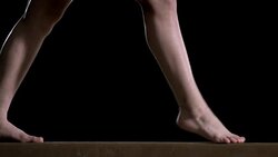 SLO MO Legs of gymnast doing leap on balance beam Stock Footage