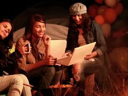 Three young women using laptop in the forest, Delhi, India Stock Footage