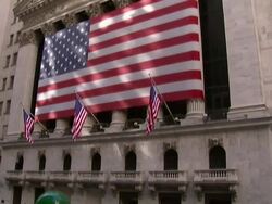 Long Shot tilt-down - A crowd gathers on Wall Street across from a large American flag on the New York Stock Exchange. / New York City, New York, USA Stock Footage