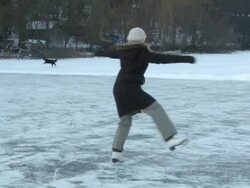 MS TS Young lady skating backwards on frozen pond in High Park and does spin and  n stops  / Toronto, Ontario, Canada  Stock Footage