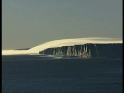 WA ice cliffs casting shadows over water, katabatic winds flowing over cliff, Antarctica Stock Footage