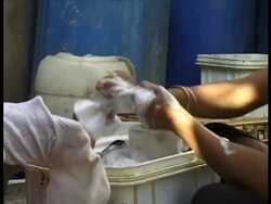 CU children by water tanks washing clothes, Egypt Stock Footage