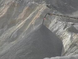 Crushed iron ore dumping off a belt. Stock Footage