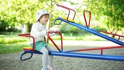 Girl playing on seesaw. Stock Footage