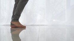Man walking on tiled white floor Stock Footage