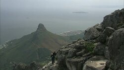 Rock climbers stand on a rocky mountainside. Stock Footage