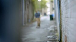 Young man rides skateboard through downtown alleyway Stock Footage