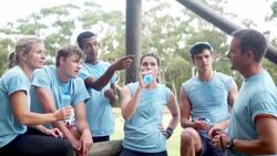 Team resting and talking at boot camp obstacle course Stock Footage