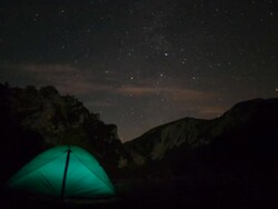 MS T/L View of tent in alpine mountains underneath starry sky at night to dawn / Bayrischzell, Bavaria, Germany Stock Footage