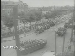 1949: COMMUNIST PARTY OF CHINA: SHANGHAI: VS CPC soldiers parading through Shanghai streets in DUKWs vehicles, saluting, Chinese men on streets cheering along, soldiers marching, people parading, Mao Zedong (unconfirmed) overseeing ceremony. Civil War Instructional Video