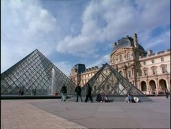 WA view of people walking amongst Glass Pyramids at the Louvre, Paris Stock Footage