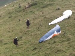 MS SLO MO Shot of Two paragliders on side of hill adjusting there parachutes Stock Footage