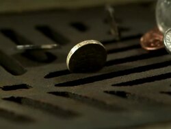 Money Down the Drain - High speed English coins falling on and in to road drain, low angle, cu Stock Footage