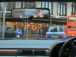 Driving in Kensington on a rainy wet day with busy traffic  in London Stock Footage