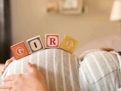 A pregnant women using blocks to spell the word GIRL on her stomach. Stock Footage
