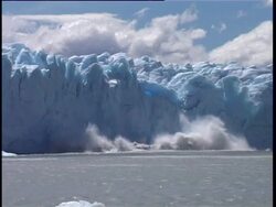 Ice breaking away from glacier and crashing into icy water below. Stock Footage