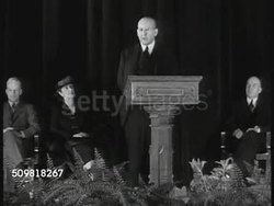 1944: SPRINGFIELD, MASSACHUSETTS: HA WS Springfield. NEWSPAPER: 'Springfield plan fights Bigotry with education'  Springfield street w/ people walking sidewalk. EXT Springfield school. INT Auditorium w/ DR. Clyde Miller speaking to parents. Audience. Instructional Video