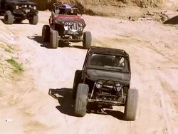 WS ZO PAN Three terrain vehicle jeeps rolling through deep trench / Salton City, California, USA Stock Footage