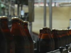 MS Perspective shot of brown glass beer bottles moving along conveyor / Wau, Western Bahr el Ghazal, Sudan  Stock Footage