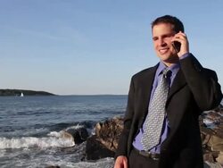 MS Man talking on mobile phone and getting exciting at ocean / Portland, ME, United States Stock Footage