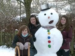 MS Women standing next to snowman after making / Saarburg, Rhineland-Palatinate, Germany Stock Footage