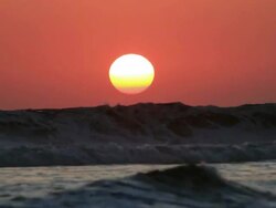 MS Sun setting behind silhouettes of big waves crashing on beach / Legian, Bali, Indonesia Stock Footage