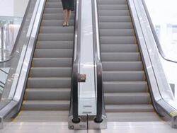  WS Businesswoman descending escalator in office building and walking away / Seattle, Washington, United States Stock Footage