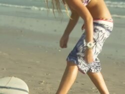 Young woman tying surfboard leash to her ankle and then walking off with surfboard, Cape Town, South Africa Stock Footage