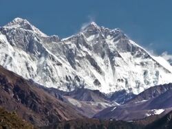 Panning shot of Time-lapse of Everest and surrounding peaks and people on a foreground trail. Stock Footage