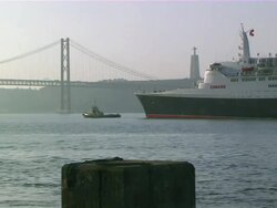 WS PAN View of ship moving near 25 de Abril bridge at Tejo river  / Lisbon, Portugal Stock Footage