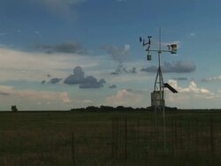 WS View of automated weather observation station with wind vane and anemometer and storm on horizon / Kansas, United States Stock Footage