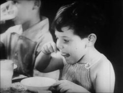 B/W 1934 close up little boy eating in nursery school / WPA project / newsreel Stock Footage