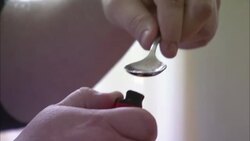 A drug user cooks a batch of heroin in a spoon. Stock Footage