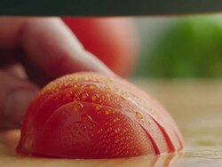 CU Half organic tomato on kitchen chopping block, sliced with steel knife / Los Angeles, California United States Stock Footage