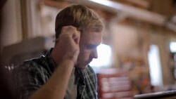 Young man works on laptop computer and takes notes with pencil Stock Footage