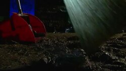 A maintenance worker sweeps up trash following an outdoor concert. Stock Footage