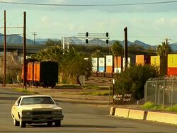 WS, Freight train moving alongside small town road, Needles, California, USA Stock Footage