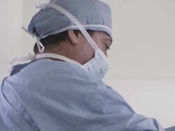 Two nurses helping prepare doctor for surgery Stock Footage