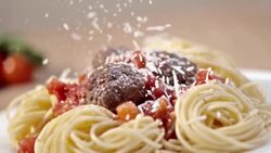 SLO MO Sprinkling parmesan over spaghetti and meatballs Stock Footage