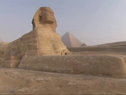 Medium Close Up, crane - The Great Sphinx sits in front of the Great Pyramids / Egypt Stock Footage