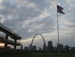 WS View of St. Louis skyline and Gateway Arch with American flag at sunset / St. Louis, Missouri, United States Stock Footage
