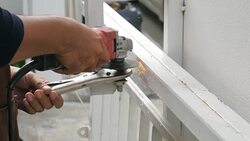 Steel Technician Sawing Steel on Fence for Repair and maintenance House , UHD format Stock Footage