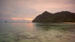 A yacht is moored in a natural harbour in the Burmese archipelago at sunrise Stock Footage