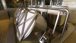 Rotating cylinders churn milk in a dairy. Stock Footage