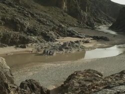 An expansive river gently flows, as mountains surround the large Moroccan valley. Stock Footage