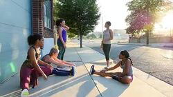 MS Female friends in discussion while stretching before early morning run Stock Footage