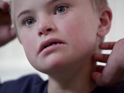 Medium shot of Downs Syndrome boy in a blue shirt Stock Footage